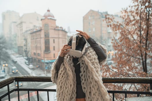 Engrossed in virtual reality, a girl stands against the backdrop of the winter city. High quality photo