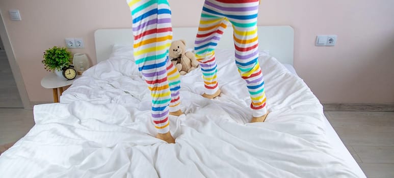 Children play jumping in bed. Selective focus. Kid.