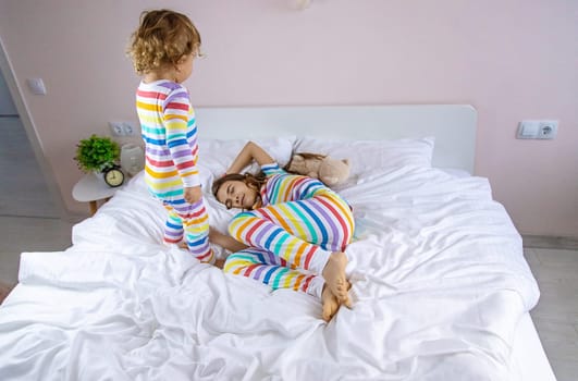 Children play jumping in bed. Selective focus. Kid.
