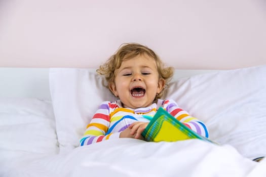 Children read a book in bed. Selective focus. Kid.