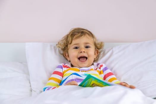 Children read a book in bed. Selective focus. Kid.