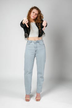 Woman With Curly Hair Giving a Thumbs Down in Studio