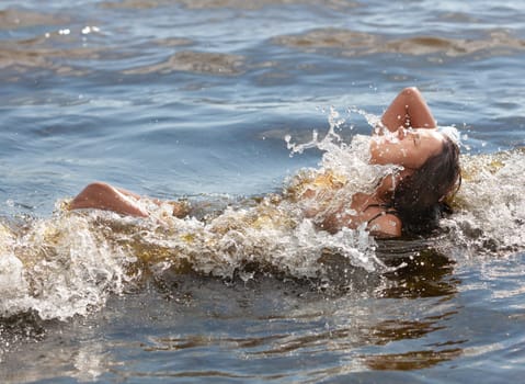 Young beautiful woman posing nude on the seaside enjoying the sea and nature