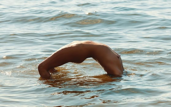 Young beautiful woman posing nude on the seaside enjoying the sea and nature