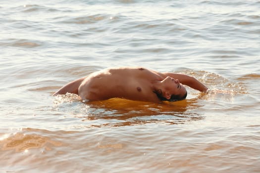 Young beautiful woman posing nude on the seaside enjoying the sea and nature