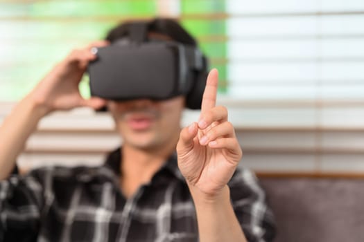 Select focus on hand. Man wearing vr headset fingers touching something.