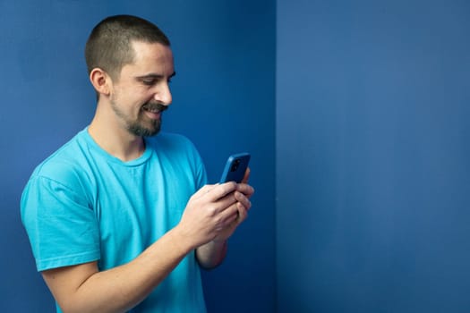 Happy young man with mobile phone on color background. High quality photo