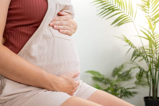 Close-up of a pregnant women touching her belly. High quality photo