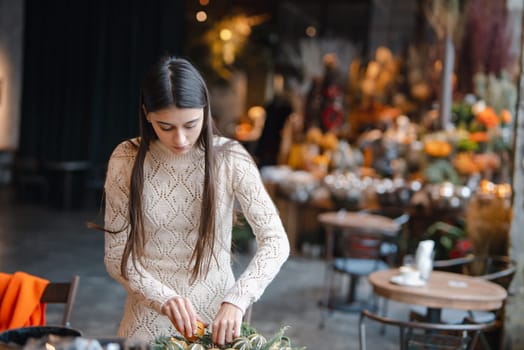 A captivating young lady enthusiastically taking part in a holiday decoration-making session. High quality photo