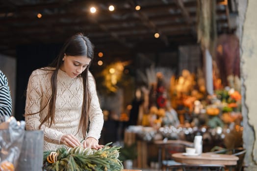 An elegant young woman passionately learning at a Christmas decor workshop. High quality photo