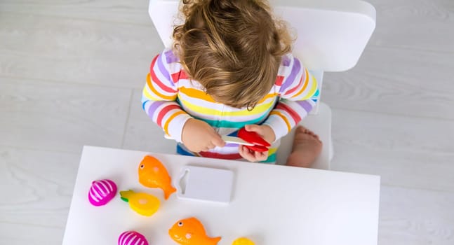 Child plays kitchen and food toys. Selective focus. Kid.