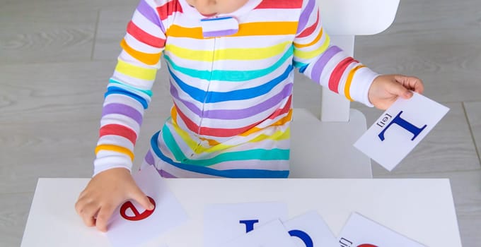 The child learns English letters. Selective focus. Kid.