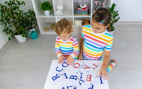 The child learns English letters. Selective focus. Kid.