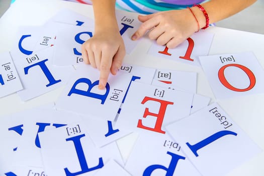 The child learns English letters. Selective focus. Kid.