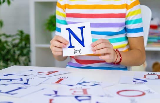 The child learns English letters. Selective focus. Kid.