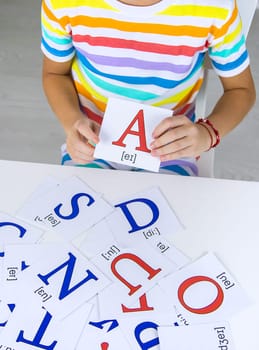 The child learns English letters. Selective focus. Kid.