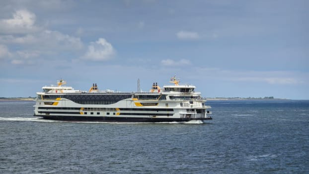 Texel Netherlands 12 May 2024,, A large ferry boat gracefully sails through the vast ocean waters near Texel, Netherlands, leaving a trail of white foam in its wake.