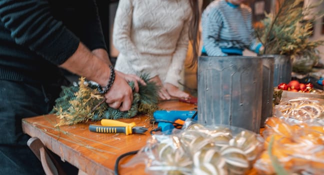 A young lady making a Christmas wreath at a DIY decor session. High quality photo