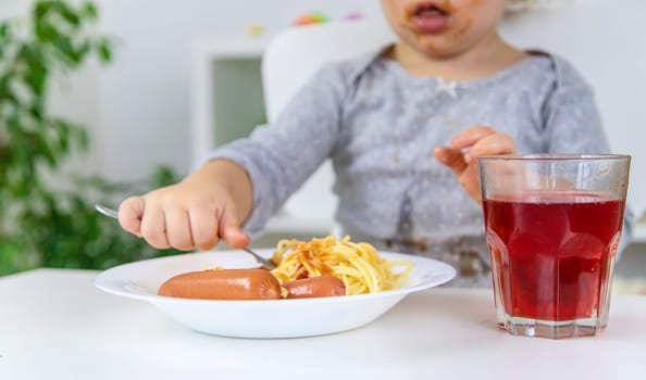 The child eats spaghetti lunch. Selective focus. Food.