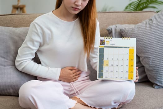 Contraception, menstruation and pregnancy concept, birth control pills asian young woman holding hormonal oral contraceptive pills with calendar, menstrual cycle. Prevention, safe virus sex disease.