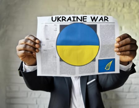 Hand holding a newspaper with the drawing of the flag of Ukraine on a white background