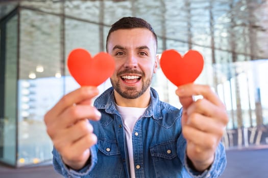 Shot smiling young woman holding hearts on Valentine's Day lovers