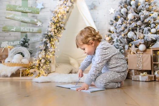 Children write a letter to Santa under the tree. Selective focus. Kid.