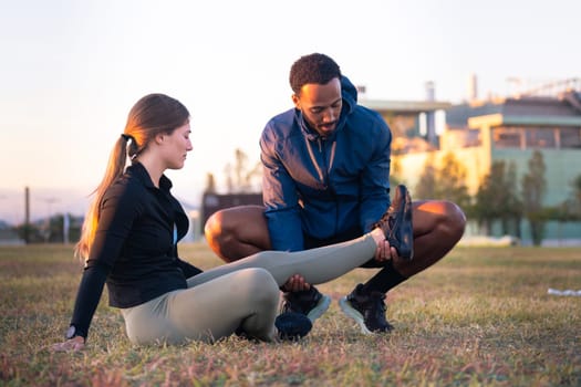 A young woman receives first aid after suffering an accident while running. Athlete Injured Leg Seen by Physical Therapist