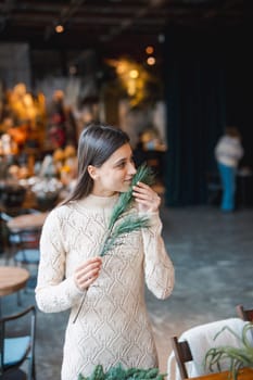 A young woman crafting a festive wreath during a decor-making seminar. High quality photo