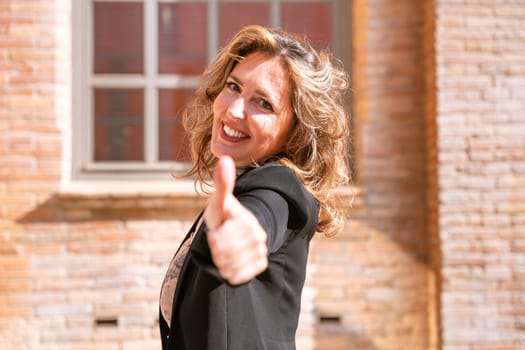 Middle-aged Caucasian woman pointing her finger forward looking at camera. Woman showing signs.