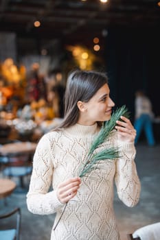 A young woman learning to make a holiday wreath at a decoration workshop. High quality photo