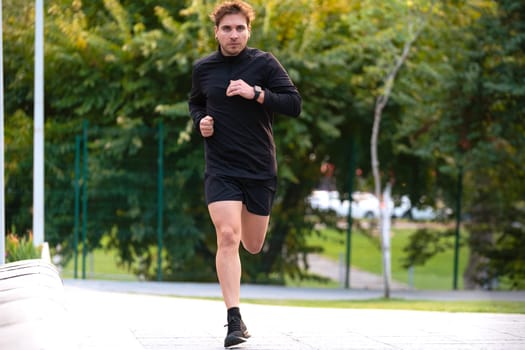 Young caucasian athlete with headphones training outdoors.