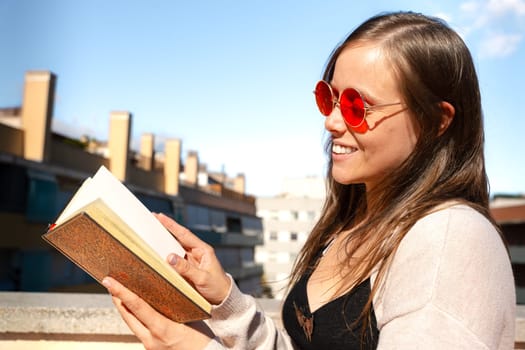 A concentrated Caucasian woman reads a book.