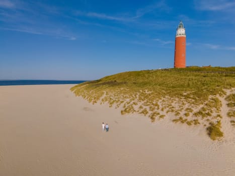 A majestic lighthouse stands tall on a sandy beach in Texel, providing guidance and protection to ships navigating the waters.