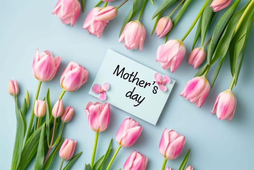 Mother's Day: top view of bouquet of pink tulips and greeting card with 8 march text on blue background