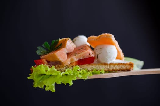 fried toast with salmon, cream cheese, salad, isolated on black background .
