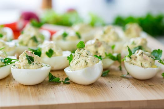 stuffed eggs, deviled eggs on a wooden table .