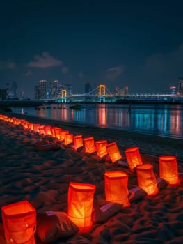 Candlelit paper lanterns create a path on a sandy Tokyo beach with city lights in the backdrop during Marine Day. Japanese Marine Day Umi no Hi also known as Ocean Day or Sea Day.