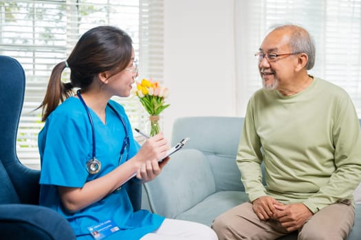 Asian young nurse writing prescription during home visit sick elder old man, Senior man takes doctor at home telling about health complaints, health care and medical concept