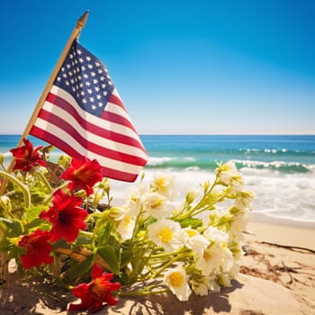 Memorial Day: American flag with flowers on the sandy beach against the background of the sea