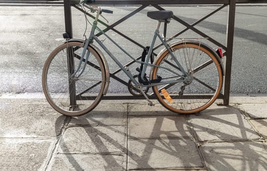 France, Paris - Jan 03, 2024 - Bicycle parked at the side of the edge of road in downtown Paris. a bicycle parked on the side in the streets, Space for text, Selective focus.