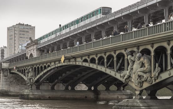 France, Paris - Jan 04, 2024 - A metro crossing the Pont de Bir Hakeim bridge over the Seine in Paris. Sculptures decorating the two level bridge Bir Akime (Steel bridge), Destinations in Europe, Space for text, Selective focus.