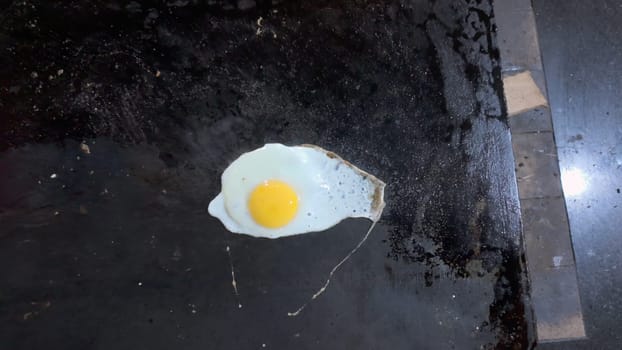 Aerial video shows an egg frying on a griddle, displaying a basic meal being cooked.