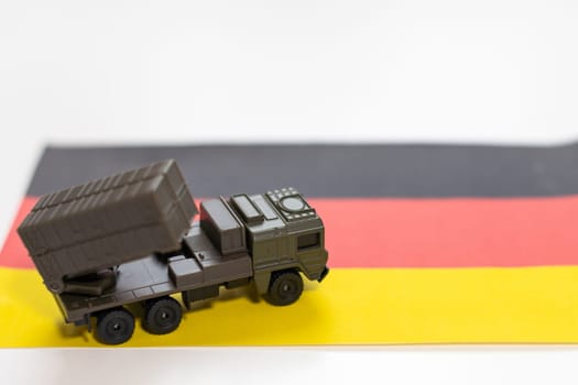 War, military threat, military power concept. Germany. Tanks toy near German flag on black background top view. High quality photo