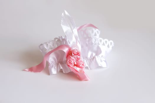 The bride's garter on a pink background. Wedding dress detail.