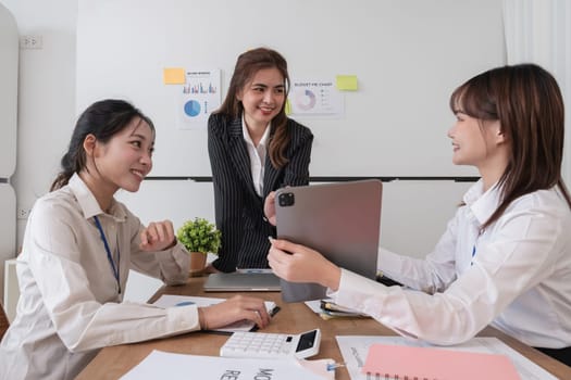 A group of Asian businesswomen in a conference room are discussing ways of working and improving their work..