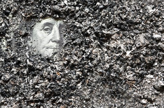 Ashes Of Former Hopes. A hundred dollar bill with Franklin's face under a layer of ashes