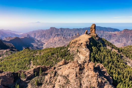 Roque Nublo and Pico de Teide in the background on Gran Canaria Island, Spain. Panoramic view of Roque Nublo sacred mountain, Roque Nublo Rural Park, Gran Canary, Canary Islands, Spain.