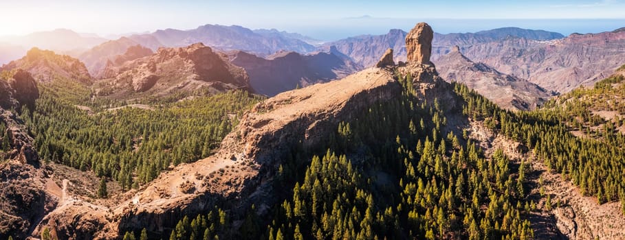 Roque Nublo and Pico de Teide in the background on Gran Canaria Island, Spain. Panoramic view of Roque Nublo sacred mountain, Roque Nublo Rural Park, Gran Canary, Canary Islands, Spain.