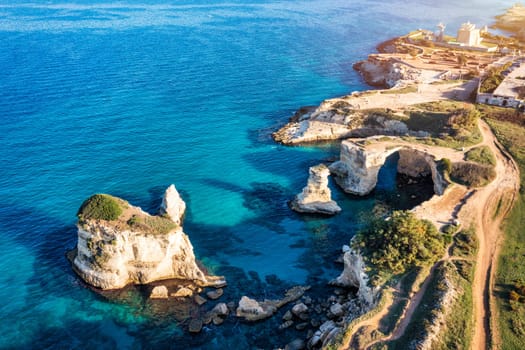 Stunning seascape with cliffs rocky arch and stacks (Faraglioni) at Torre Sant Andrea, Salento coast, Puglia region, Italy. Beautiful cliffs and sea stacks of Sant'Andrea, Salento, Apulia, Italy